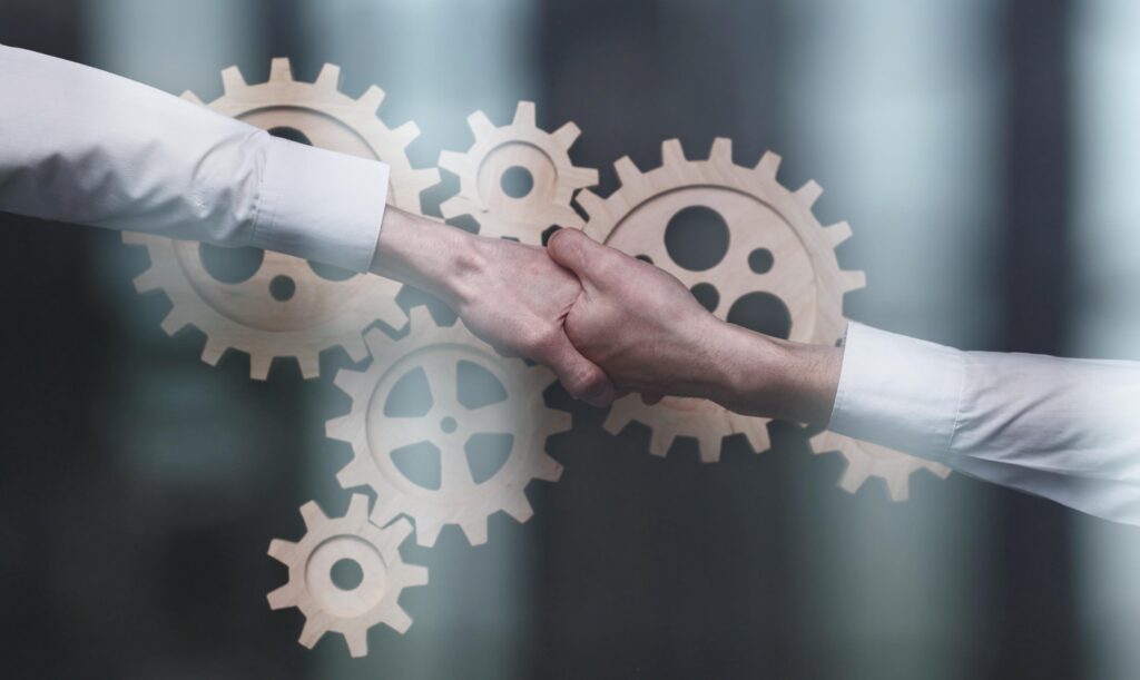 businessmen-suits-shake-hands-gears-as-symbol-business-processes-company